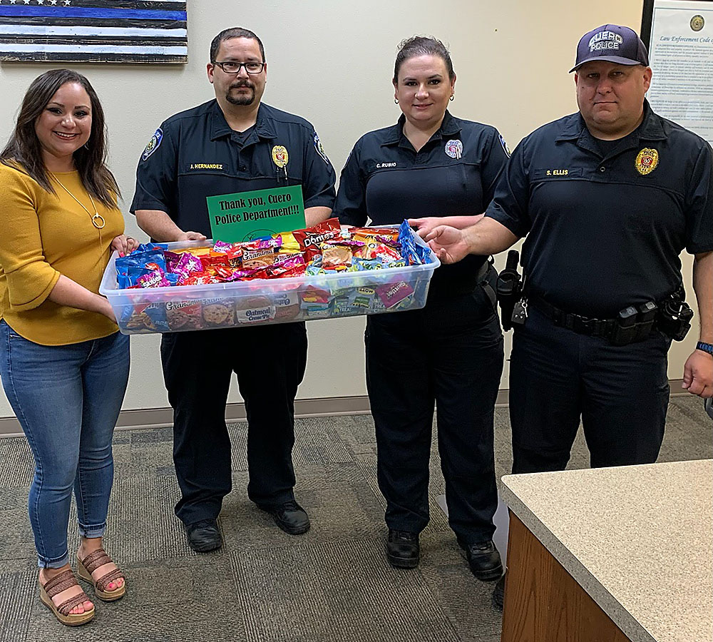 Photo of December Events Committee presenting “thank you” snack care package to City of Cuero Police Department