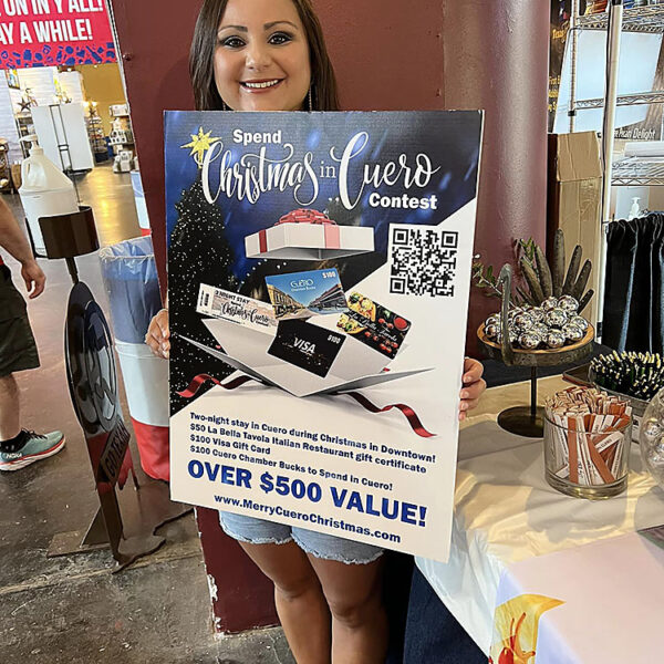 Texas State Fair 2022 - Day 1 - Photo of Samantha Bayfus holding a card promoting the “Spend a Christmas in Cuero” Giveaway